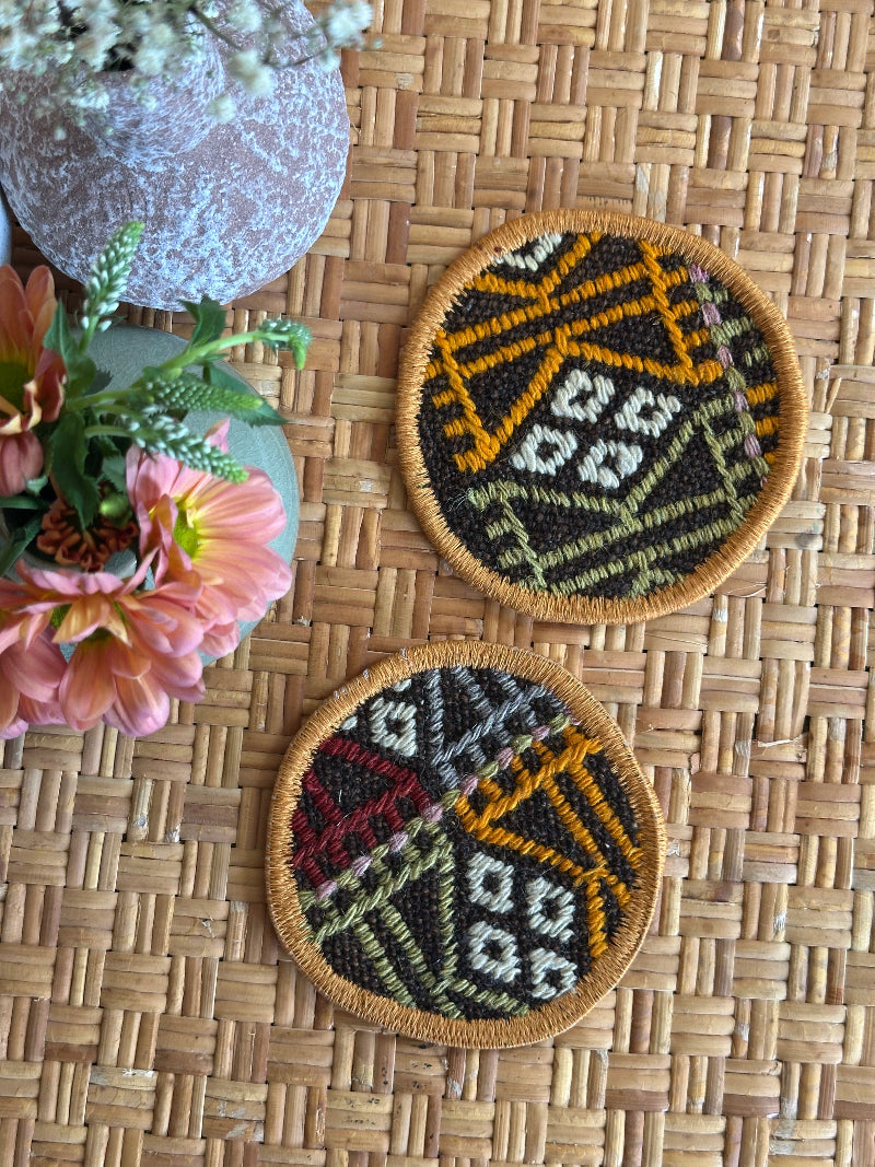 Handmade Turkish rug coasters with orange trim, repurposed from vintage rugs for a unique, sustainable home decor accent