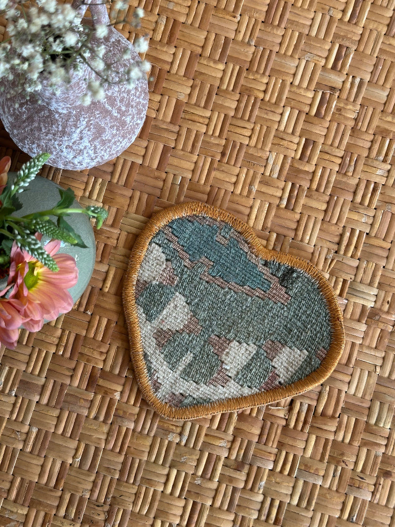 Heart-shaped Turkish rug hot plate with neutral tones and geometric patterns, handcrafted from repurposed vintage rugs for a unique, sustainable home accent