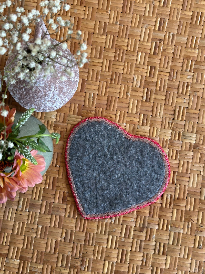 six inch heart-shaped Turkish rug hot plate made from repurposed vintage rugs with light green and brown tones and embroidered trim, perfect for hot pans, plants, or decor.