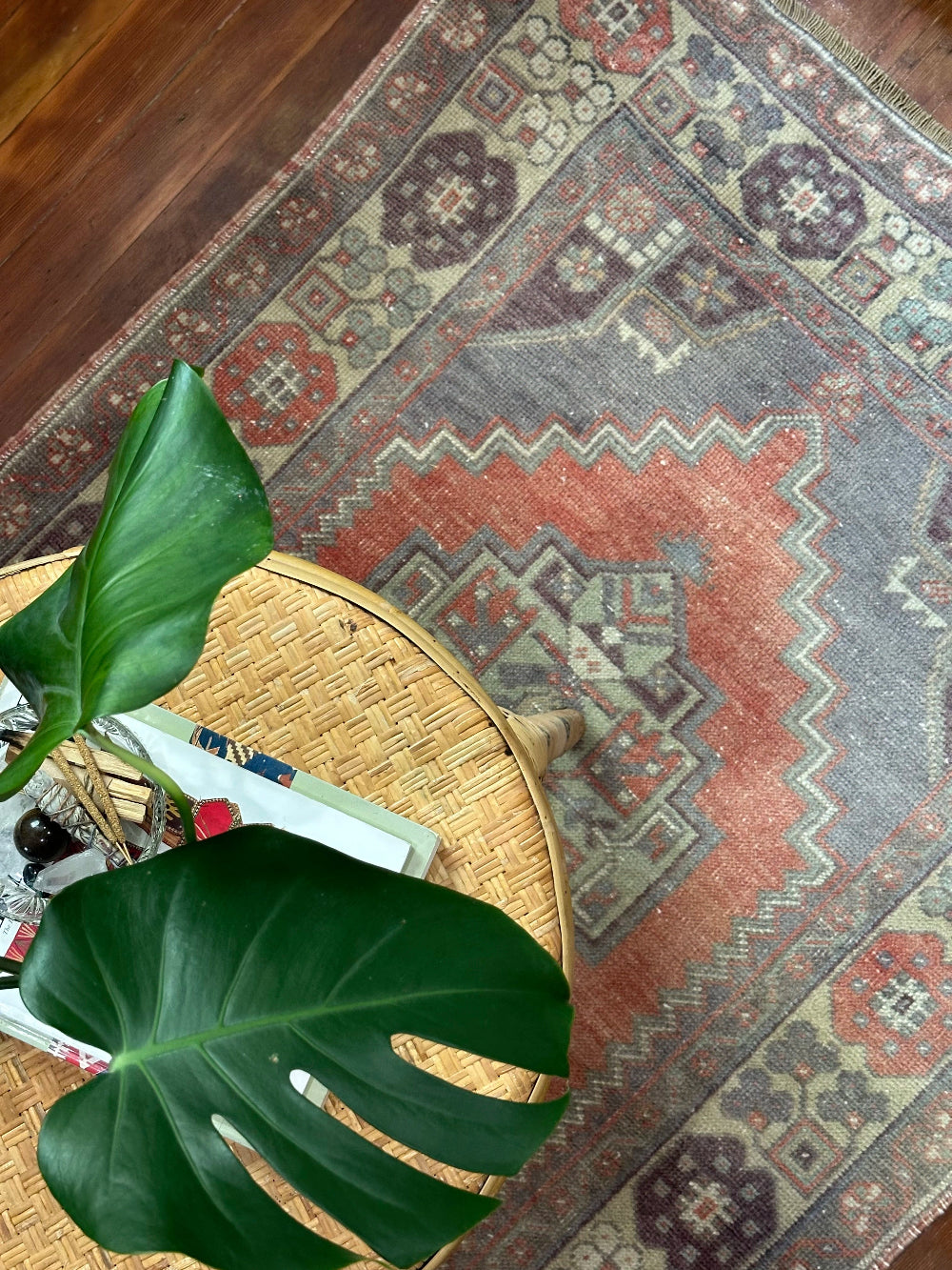 Vintage Turkish handwoven wool rug featuring a double medallion design in muted red, blue, and sage green tones with a detailed floral border.