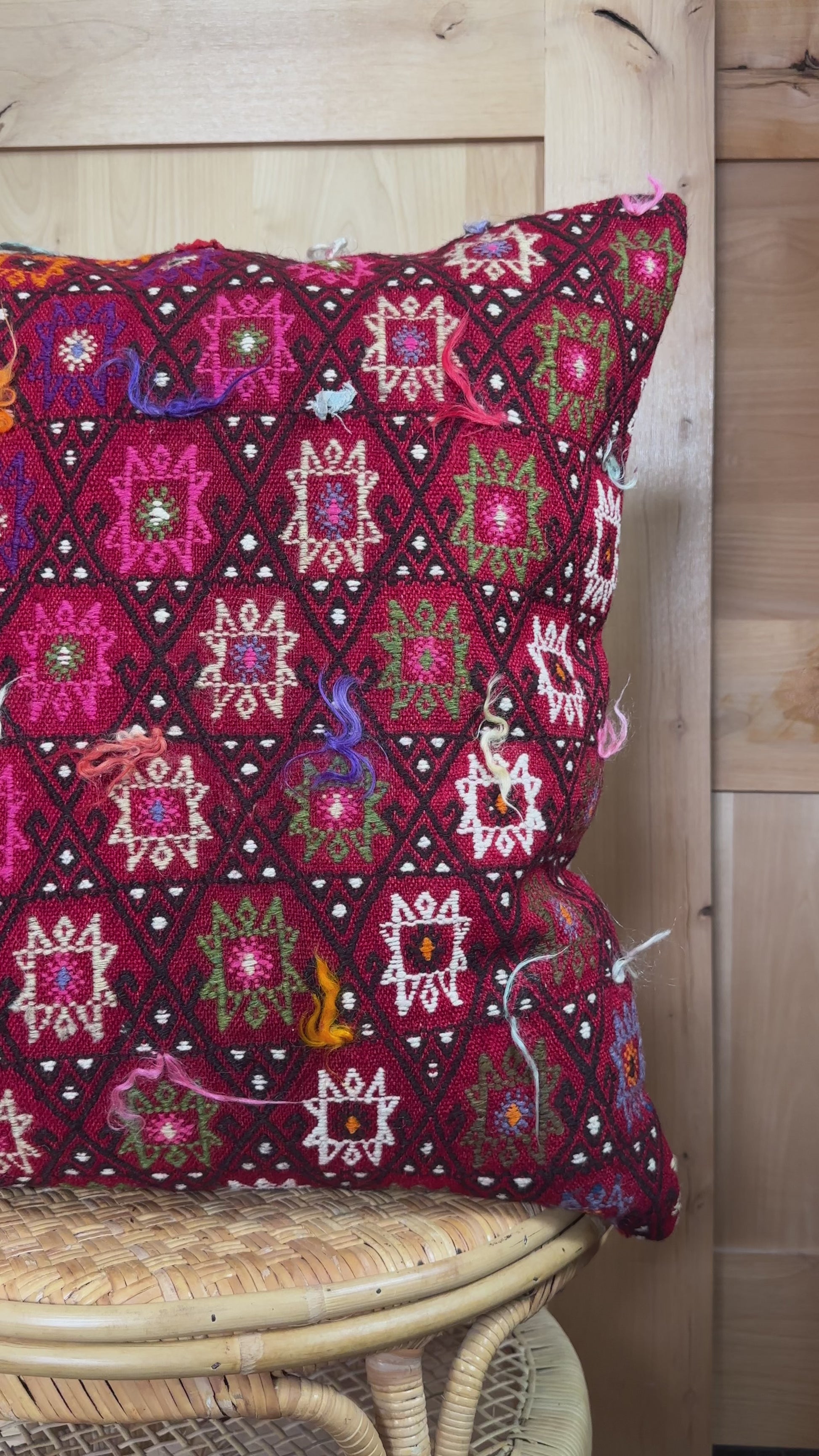 Bold handcrafted kilim pillow with intricate Berber-inspired embroidery. Made from repurposed vintage textiles in deep red, magenta, and orange hues with textured fringe details.