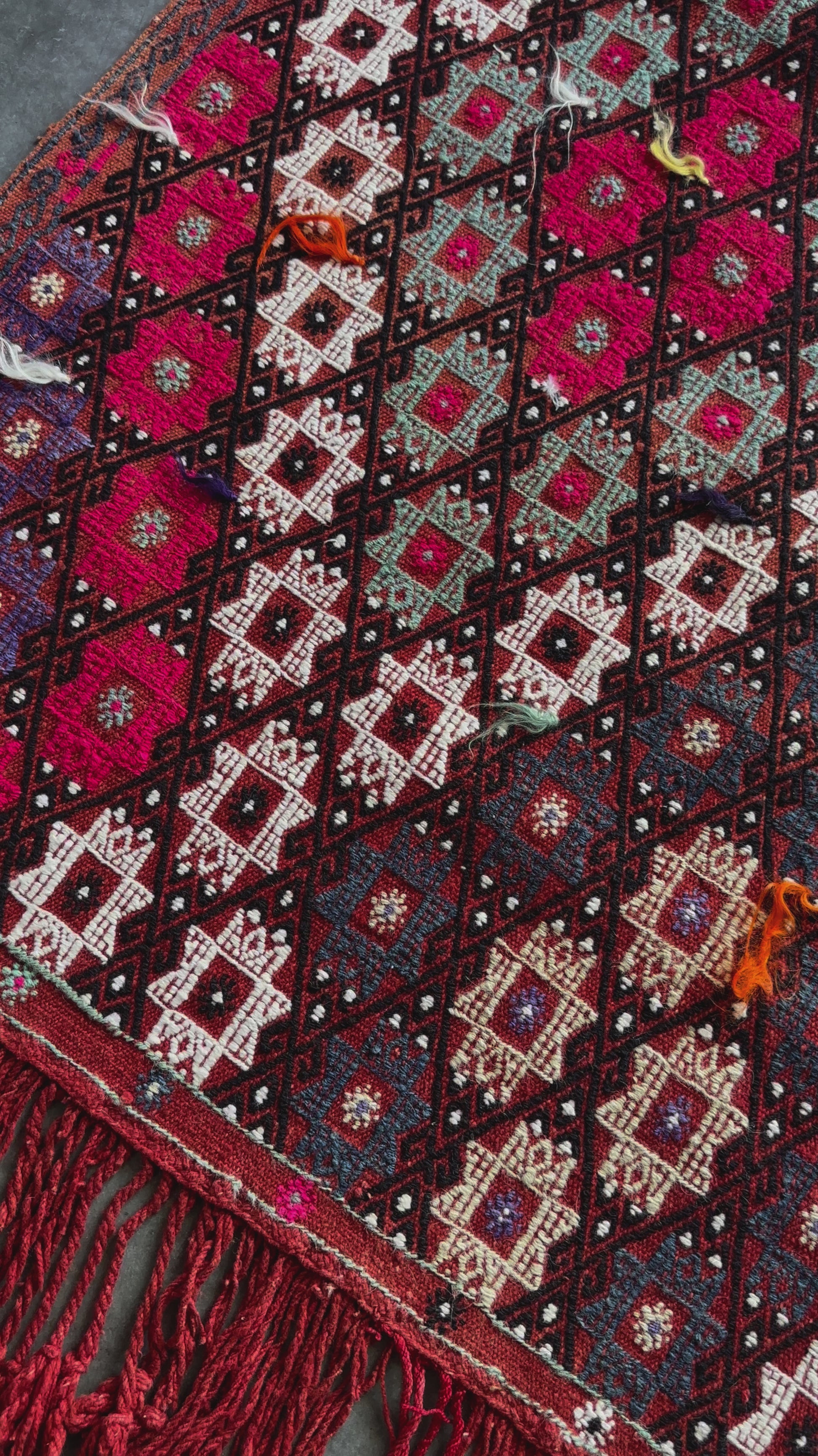 5.5 by 3.8 ft red Turkish area rug and tapestry with fringe, featuring white, pink, purple and blue 8-pointed stars