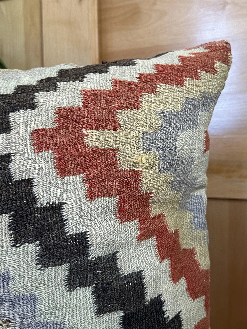 26 by 26 neutral geometric throw pillow featuring a zig-zag colorful pattern throughout