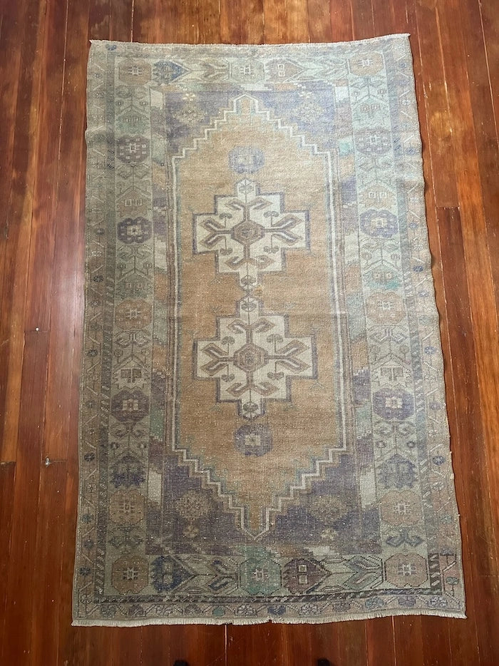 4 by 7 neutral Turkish area rug featuring a beautiful floral border and pops of lavendar and sky blue.