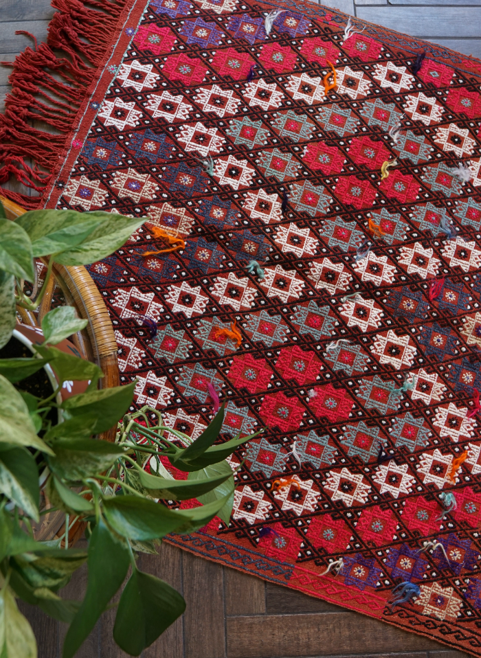 5.5 by 3.8 ft red Turkish area rug and tapestry with fringe, featuring white, pink, purple and blue 8-pointed stars