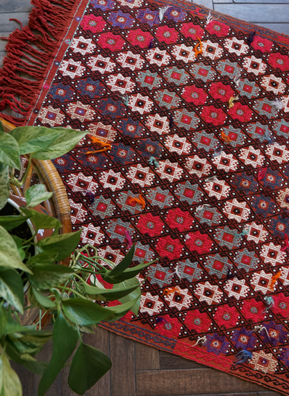 5.5 by 3.8 ft red Turkish area rug and tapestry with fringe, featuring white, pink, purple and blue 8-pointed stars