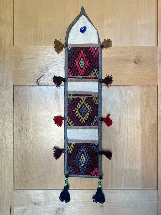 pink, yellow and rust colored fabric 3 pocket wall organizer made from turkish rug fragments