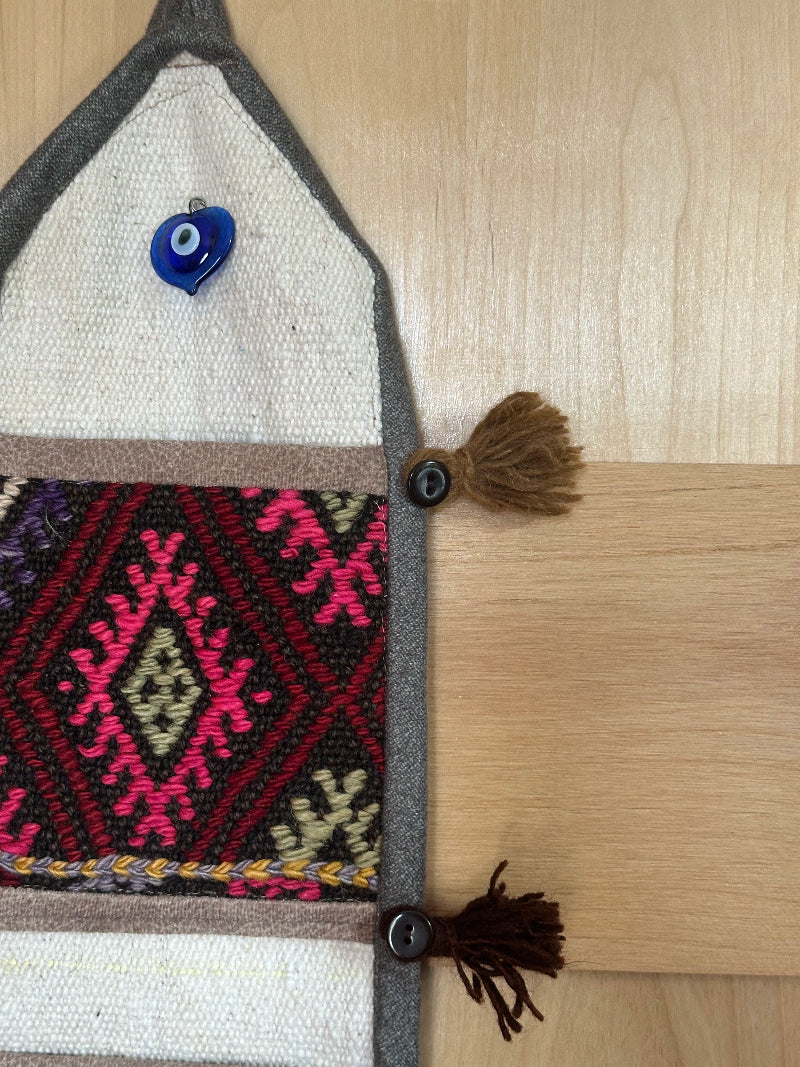 pink, yellow and rust colored fabric 3 pocket wall organizer made from turkish rug fragments