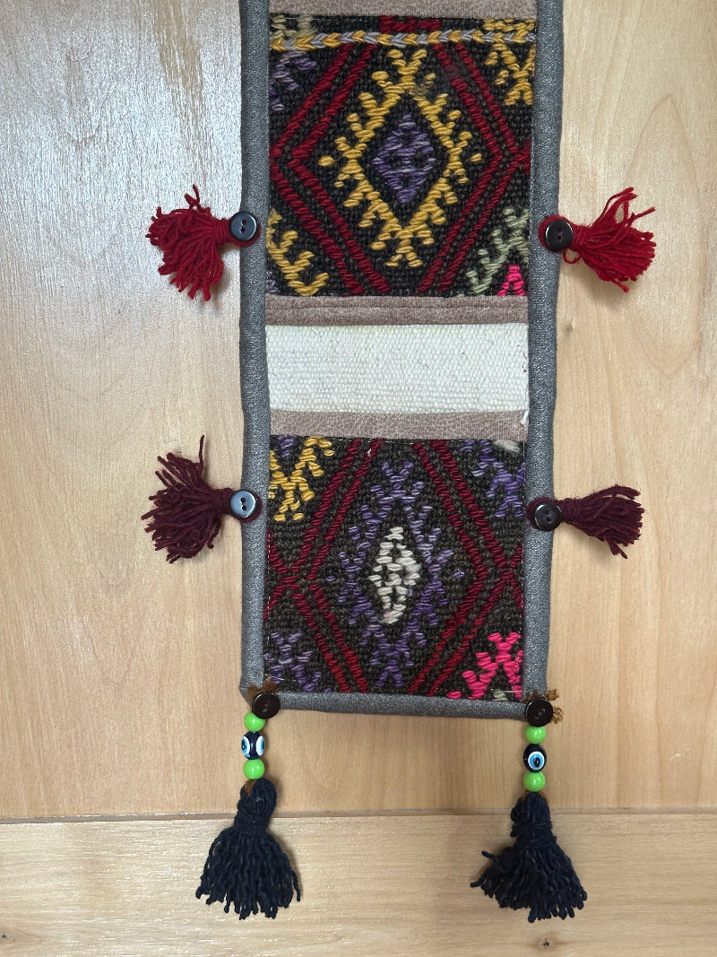 pink, yellow and rust colored fabric 3 pocket wall organizer made from turkish rug fragments