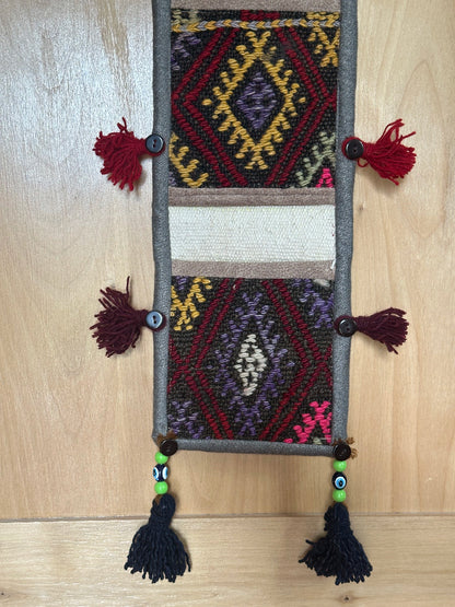 pink, yellow and rust colored fabric 3 pocket wall organizer made from turkish rug fragments
