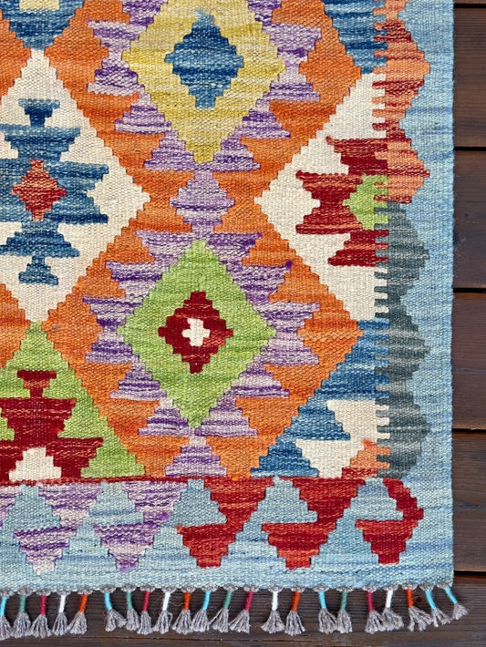 3.5 foot by 2.5 foot small kilim mini rug featuring a multicolored rainbow diamond pattern 