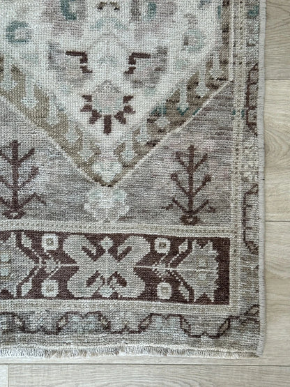 Neutral Turkish area rug featuring soft brown and tan tones with pops of blue and geometric designs