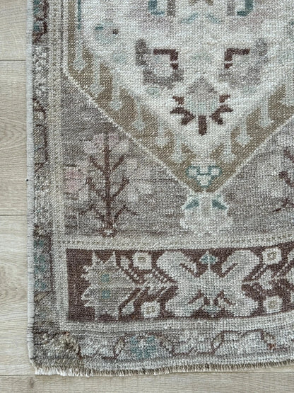 Neutral Turkish area rug featuring soft brown and tan tones with pops of blue and geometric designs