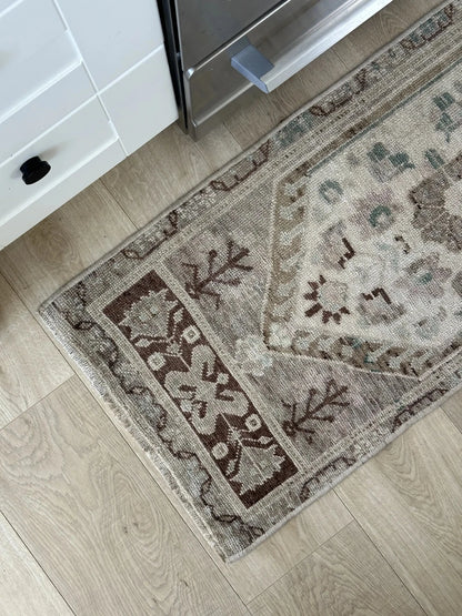 Neutral Turkish area rug featuring soft brown and tan tones with pops of blue and geometric designs