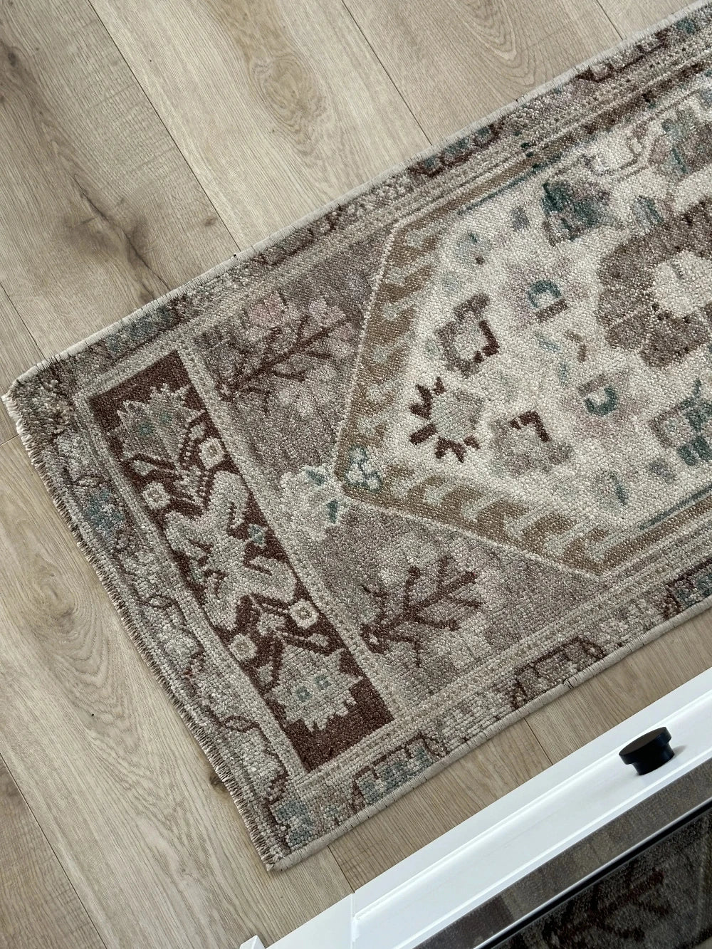 Neutral Turkish area rug featuring soft brown and tan tones with pops of blue and geometric designs