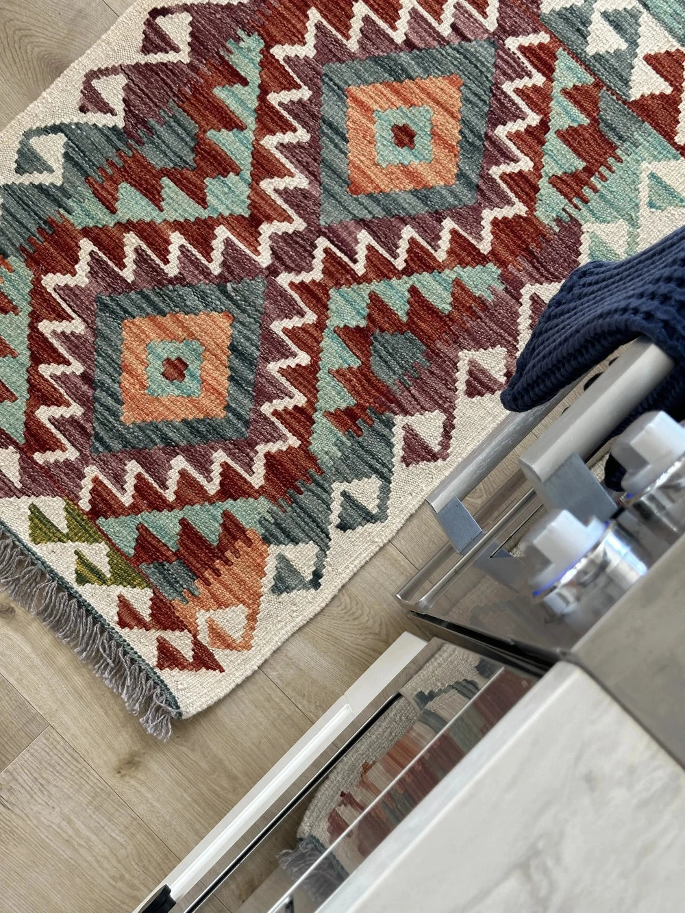 mini colorful Turkish rug featuring pops of red, orange green and blue and geometric diamond pattern throughout