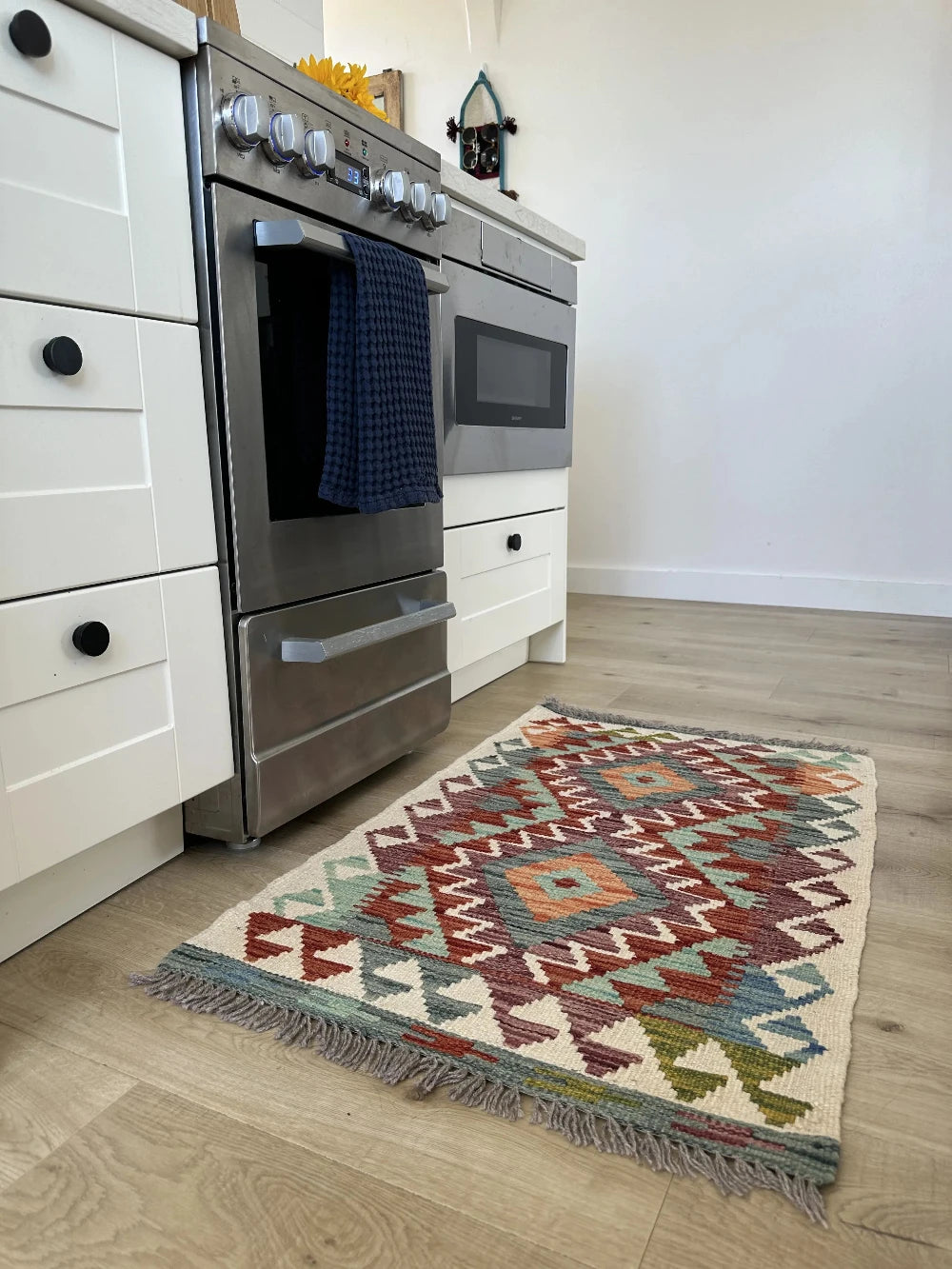 mini colorful Turkish rug featuring pops of red, orange green and blue and geometric diamond pattern throughout