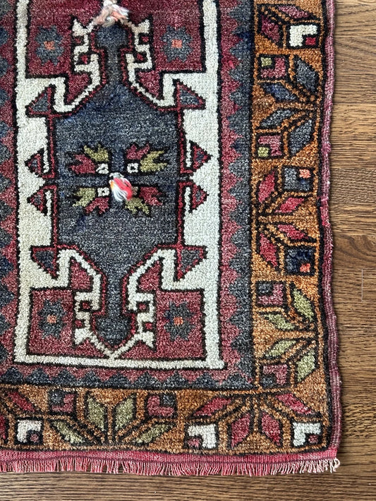 colorful mini turkish rug featuring pops of orange, green, navy and mauve and geometric patterns throughout