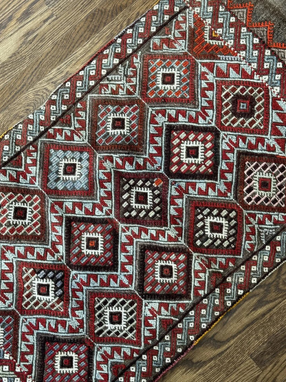 Mini Turkish Rug featuring pops of red and light blue with a repeating diamond pattern throughout