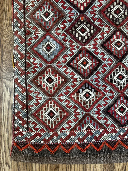 Mini Turkish Rug featuring pops of red and light blue with a repeating diamond pattern throughout