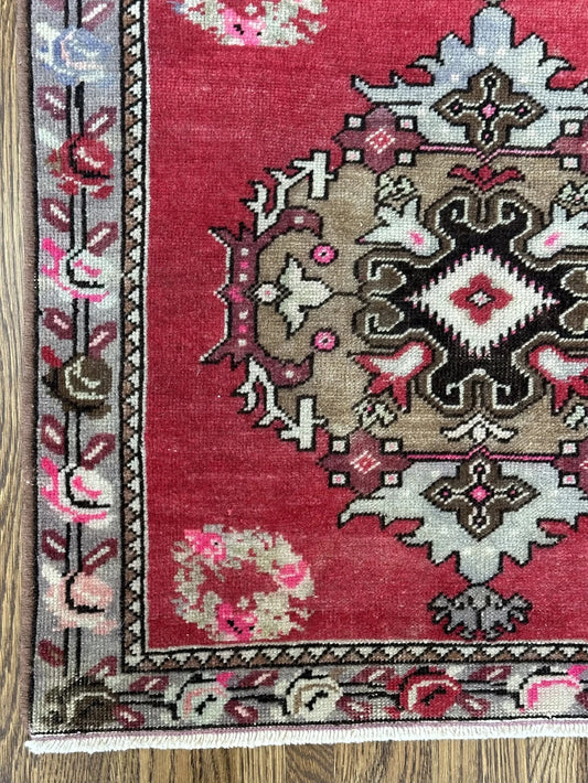 square mini red Turkish rug with a rose patterned border and large geometric medallion center