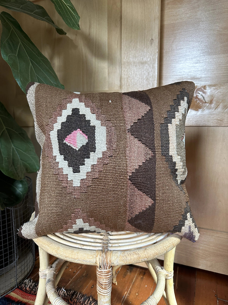 Handwoven brown Turkish throw pillow, 16x16 inches, wool front with geometric design and pops of light grey and pink, cotton backing—boho home decor.