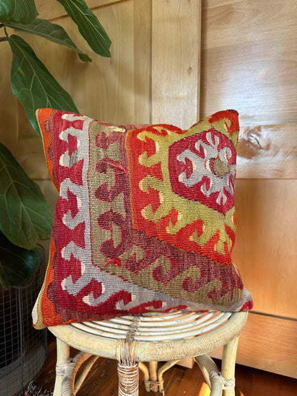 Handwoven red and green Turkish throw pillow, 16x16 inches, wool front with geometric design and pops of light blue and maroon, cotton backing—boho home decor.