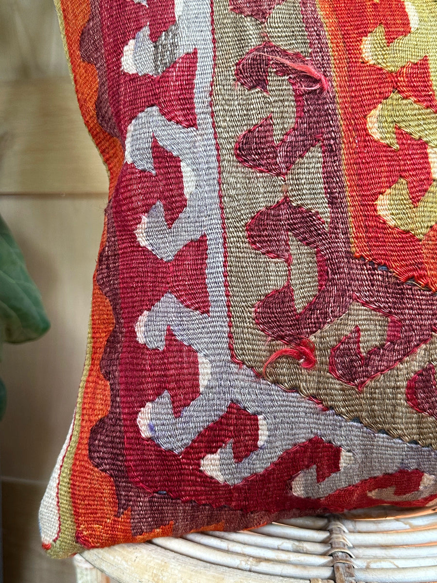 Handwoven red and green Turkish throw pillow, 16x16 inches, wool front with geometric design and pops of light blue and maroon, cotton backing—boho home decor.