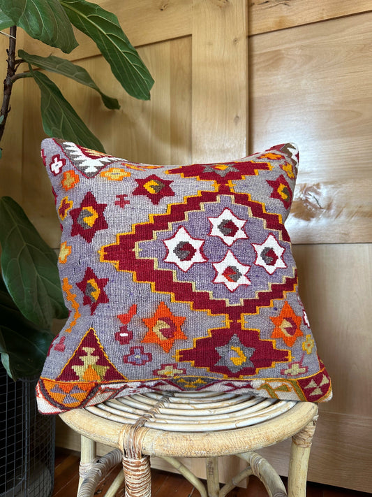 Handwoven purple Turkish throw pillow, 16x16 inches, wool front with geometric star design and pops of orange and red, cotton backing—boho home decor.