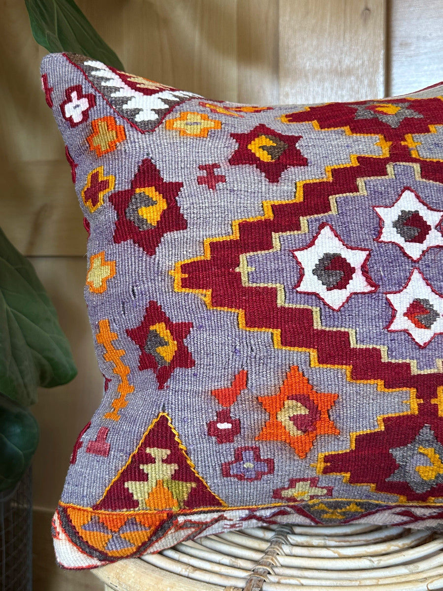 Handwoven purple Turkish throw pillow, 16x16 inches, wool front with geometric star design and pops of orange and red, cotton backing—boho home decor.