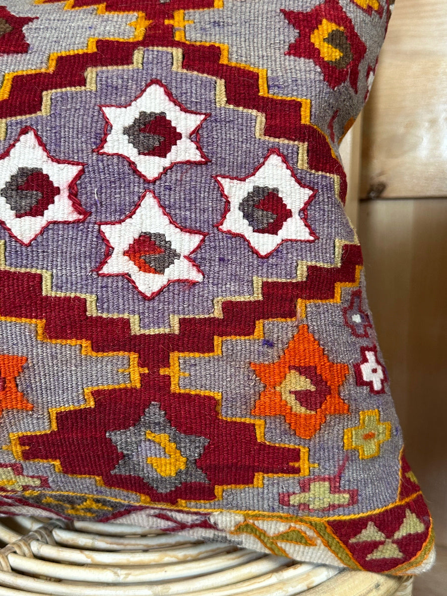 Handwoven purple Turkish throw pillow, 16x16 inches, wool front with geometric star design and pops of orange and red, cotton backing—boho home decor.