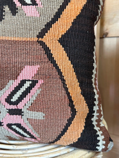 Handwoven earthy brown Turkish throw pillow, 16x16 inches, wool front with geometric design and pops of pink and faded orange, cotton backing—boho home decor.