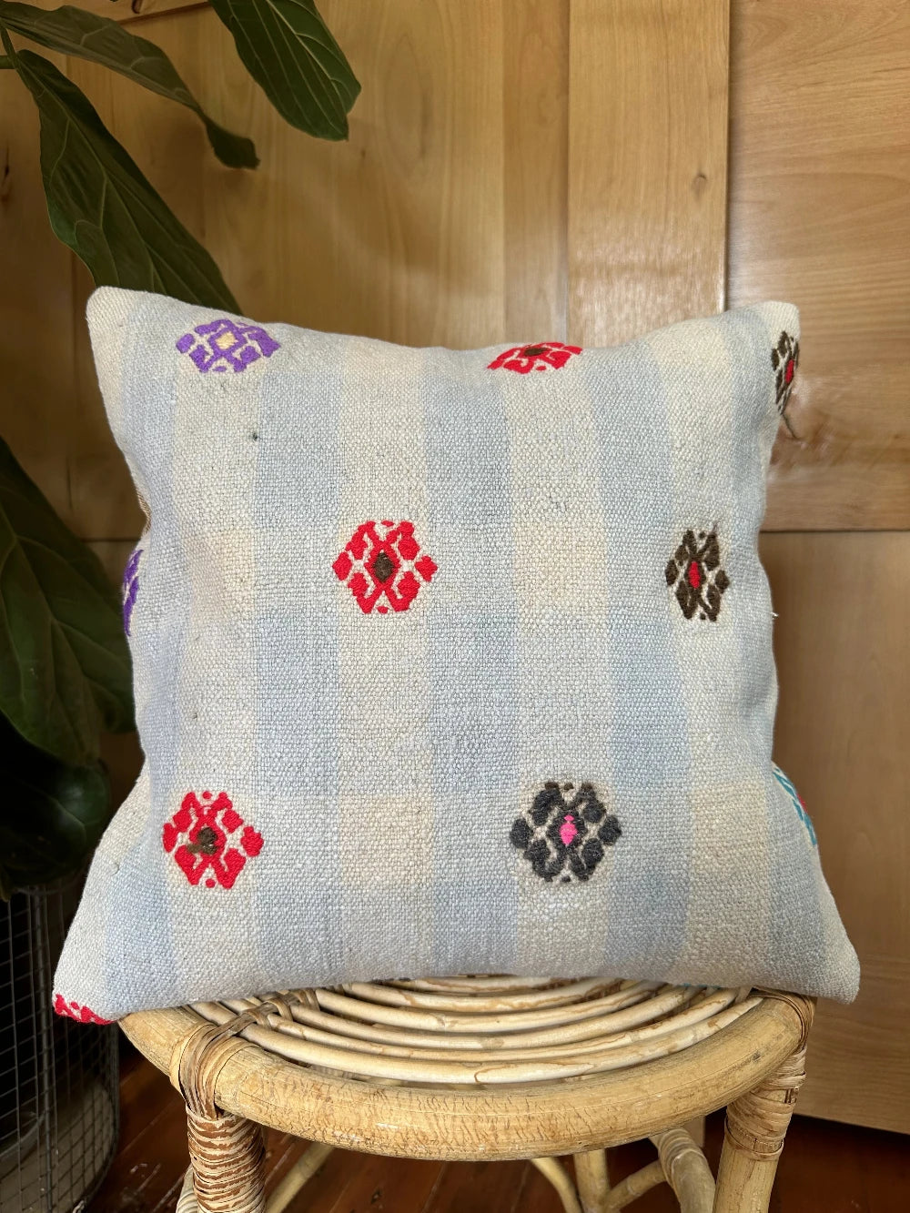 16 by 16 cream and light blue turkish throw pillow featuring purple, red and green embroidered flowers throughout