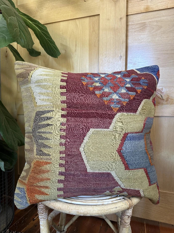 20 by 20 geometric turkish pillow with deep red hues and light yellow and blue