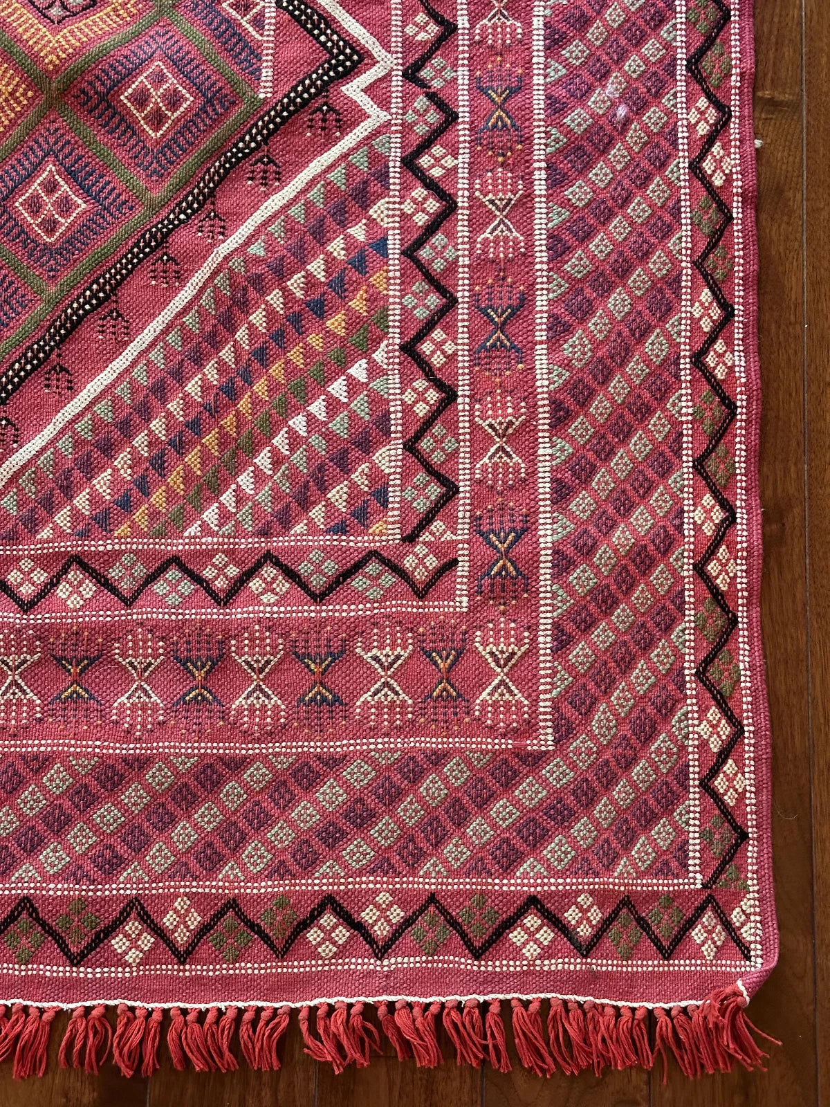 Flatwoven Turkish cicim are rug featuring geometric borders and fields throughout and a bright pink all over color with small accents of light blue, purple, yellow, green and white