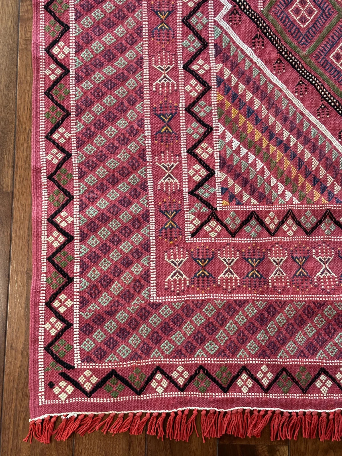 Flatwoven Turkish cicim are rug featuring geometric borders and fields throughout and a bright pink all over color with small accents of light blue, purple, yellow, green and white