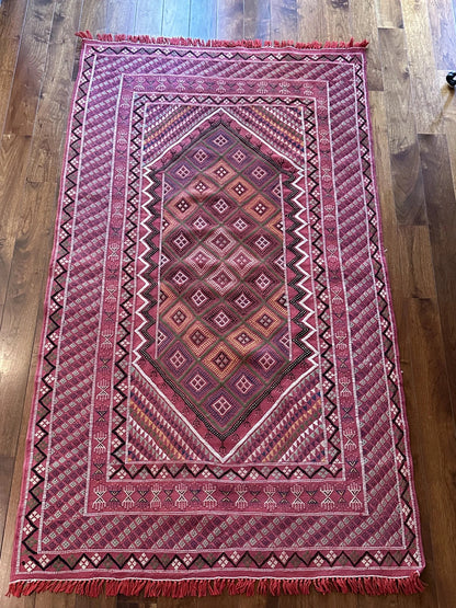 Flatwoven Turkish cicim are rug featuring geometric borders and fields throughout and a bright pink all over color with small accents of light blue, purple, yellow, green and white