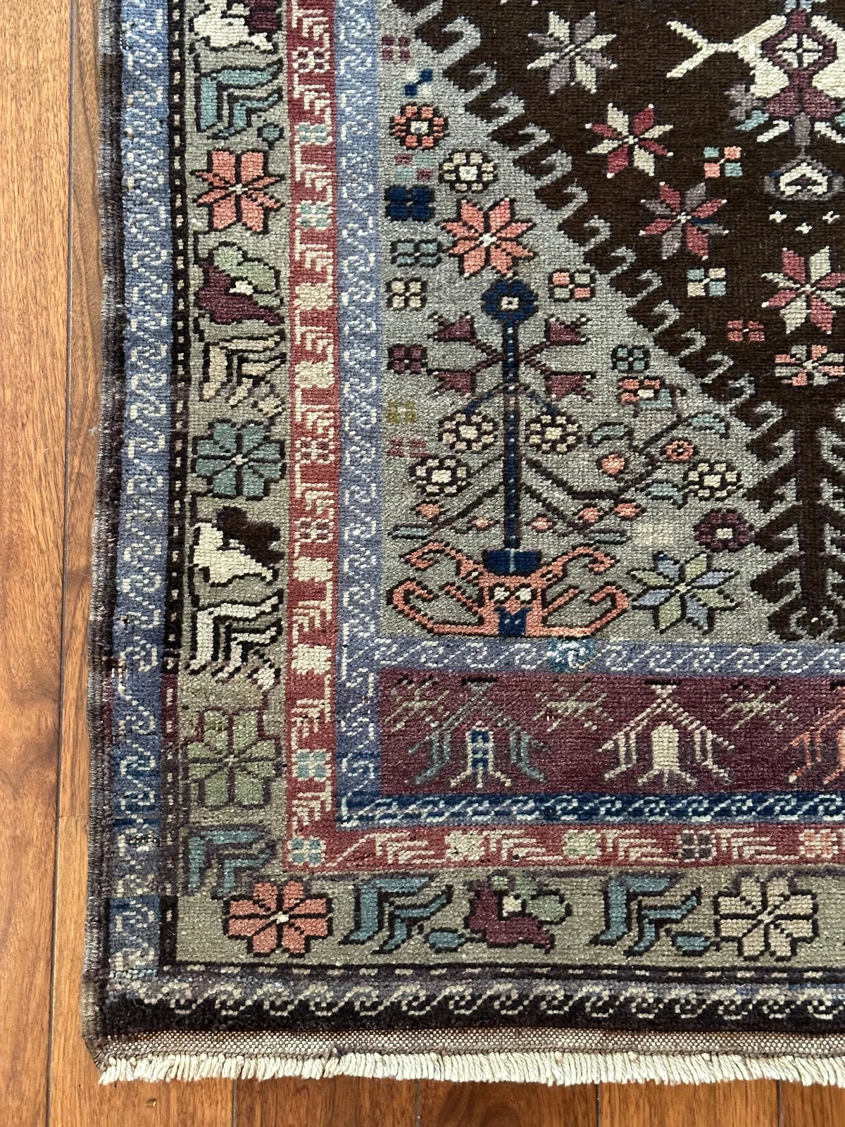 Large vintage Turkish rug featuring floral and geometric designs with hues of navy, robin eggs blue, olive, mauve and taupe.