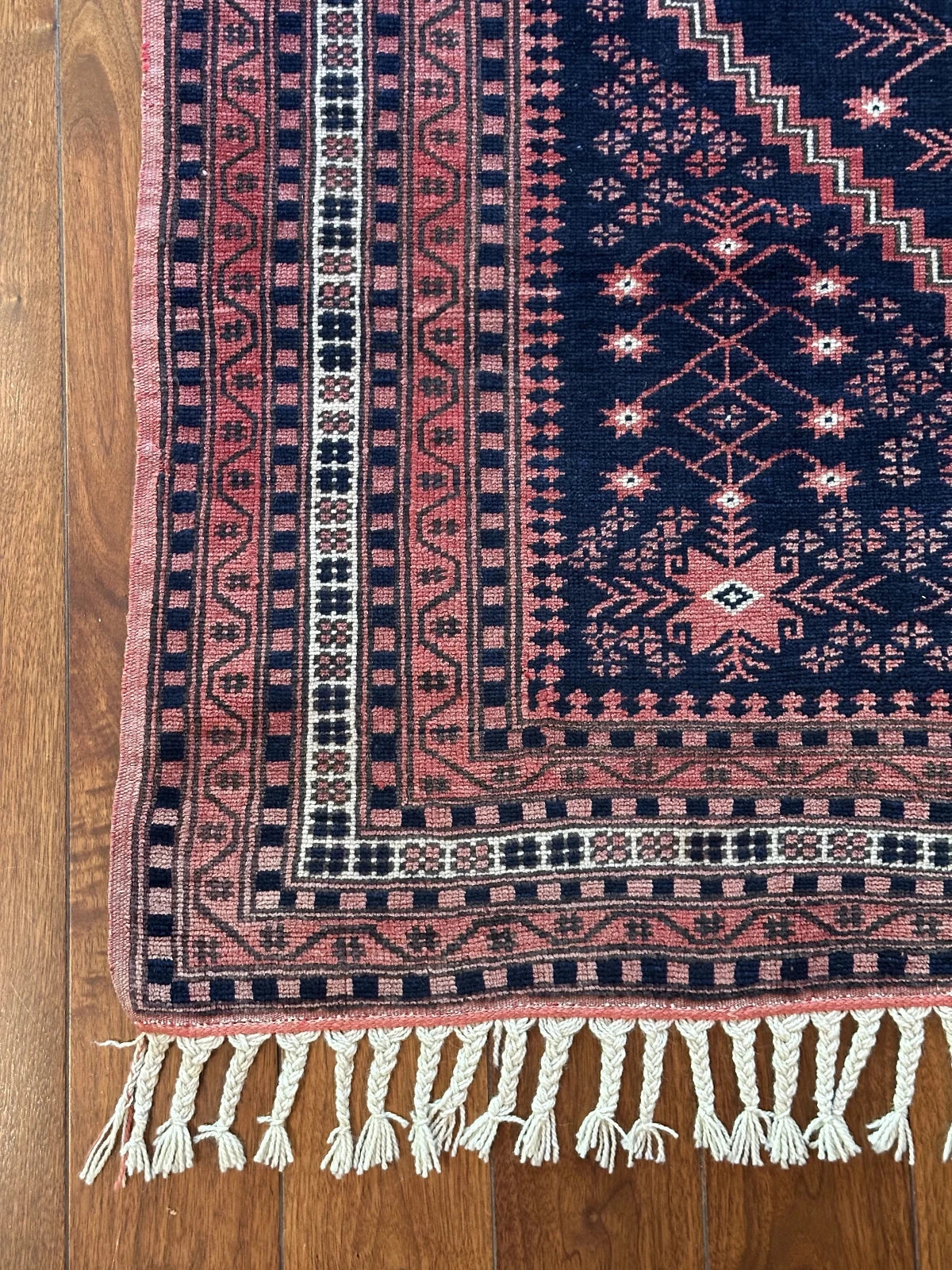 Handmade Turkish rug featuring navy and raspberry hues and 7 different borders with floral and geometric designs