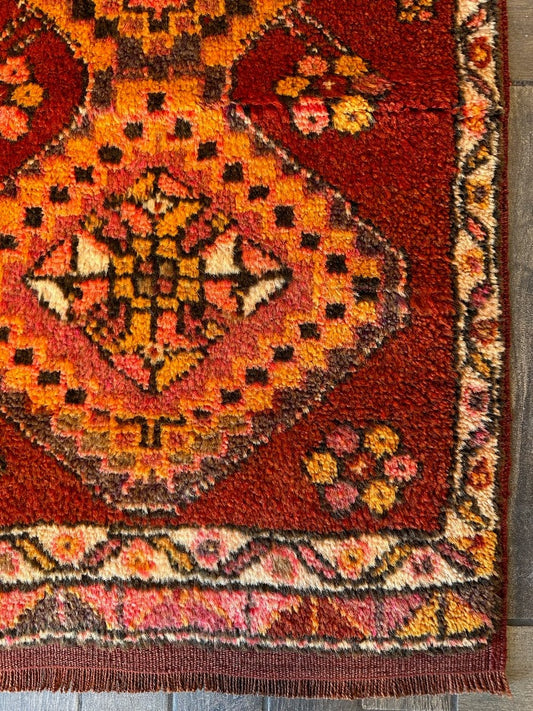 3 by 2 small Turkish area rug featuring sunset orange, red and pink coloring and two large medallions on the center with flowers around