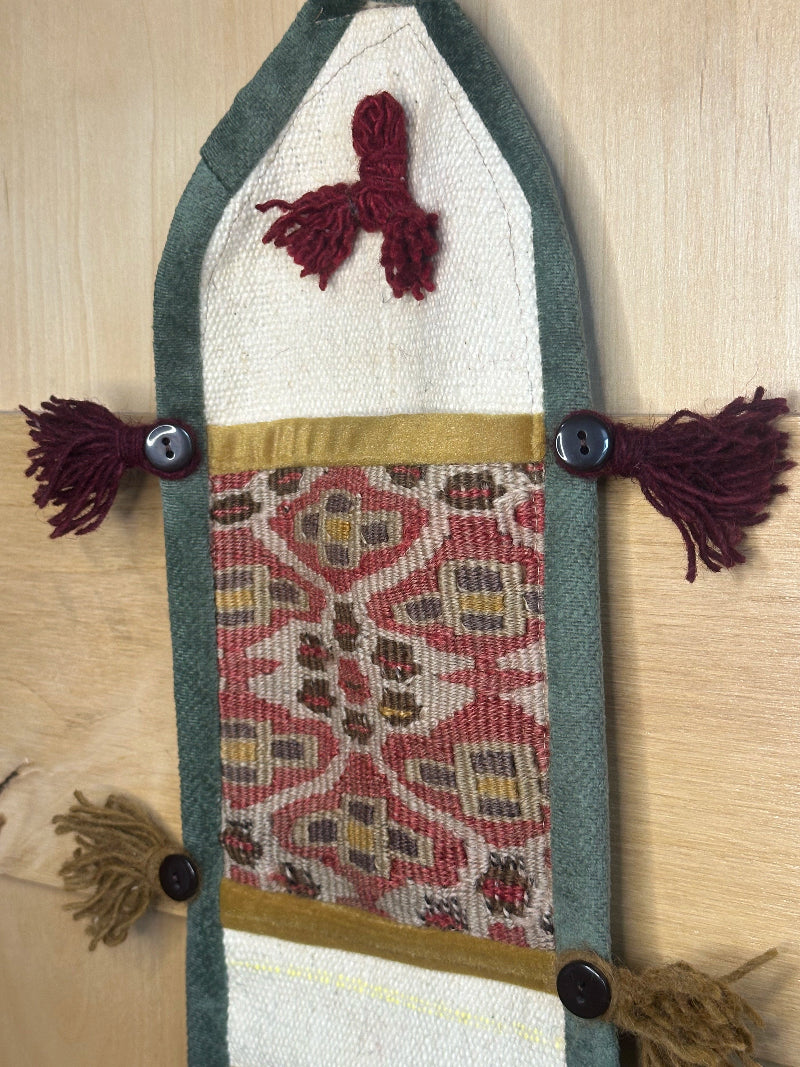 Handmade decorative Turkish rug wall organizer with pink geometric designs, 3 pockets, tassels, and an evil eye charm. Upcycled vintage textile art by High Pile Designs.