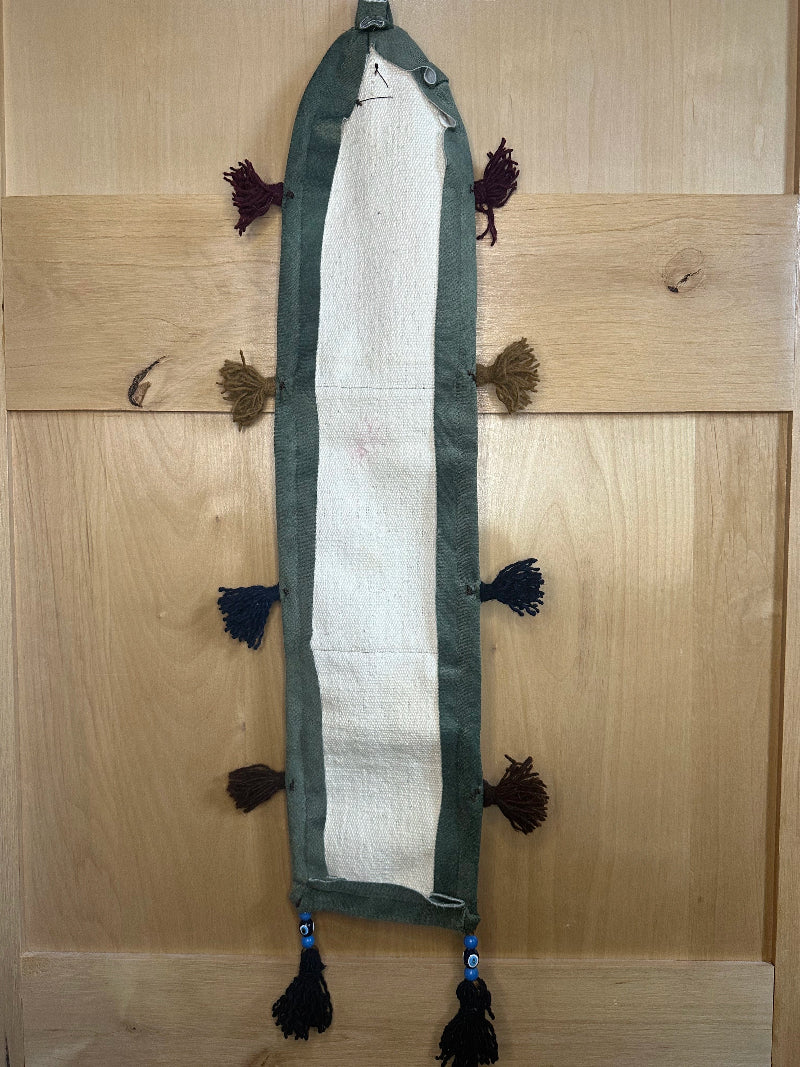 Handmade decorative Turkish rug wall organizer with pink geometric designs, 3 pockets, tassels, and an evil eye charm. Upcycled vintage textile art by High Pile Designs.