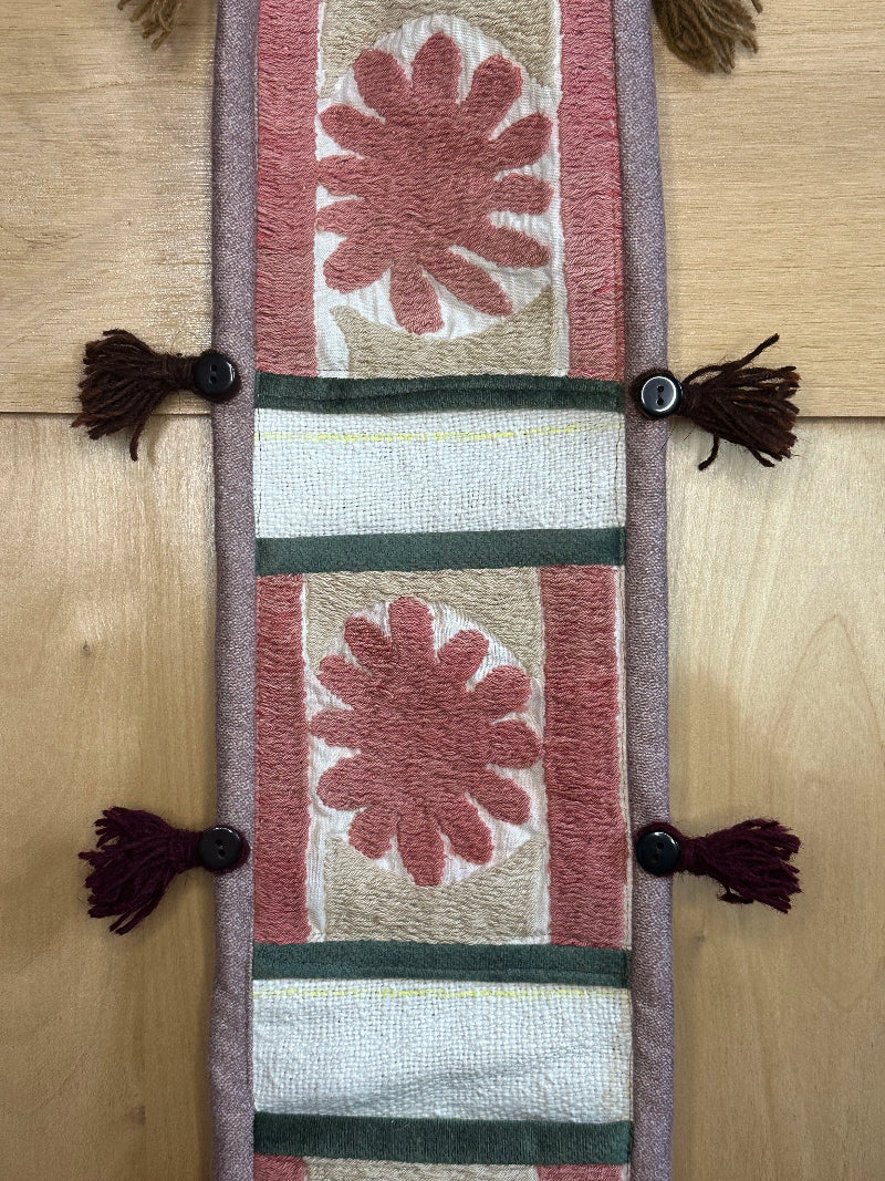Handmade Turkish rug wall hanging with pink floral designs, 3 pockets, tassels, and evil eye charm. Upcycled vintage textile art by High Pile Designs.