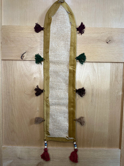 Handmade Turkish rug wall hanging with geometric designs, 3 pockets, tassels, and an evil eye charm. Upcycled vintage textile art by High Pile Designs.