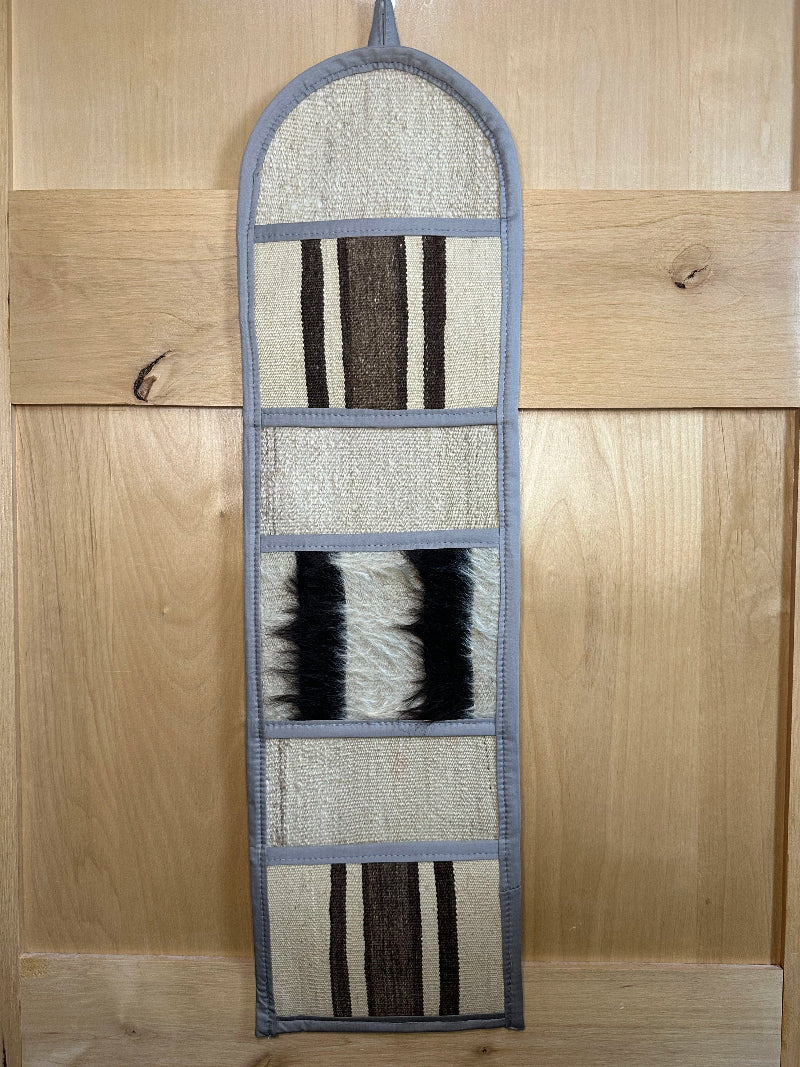 Decorative, handmade Turkish rug wall organizer with neutral stripe designs and 3 storage pockets. Upcycled vintage textile art by High Pile Designs. Featuring a wrapped gift.