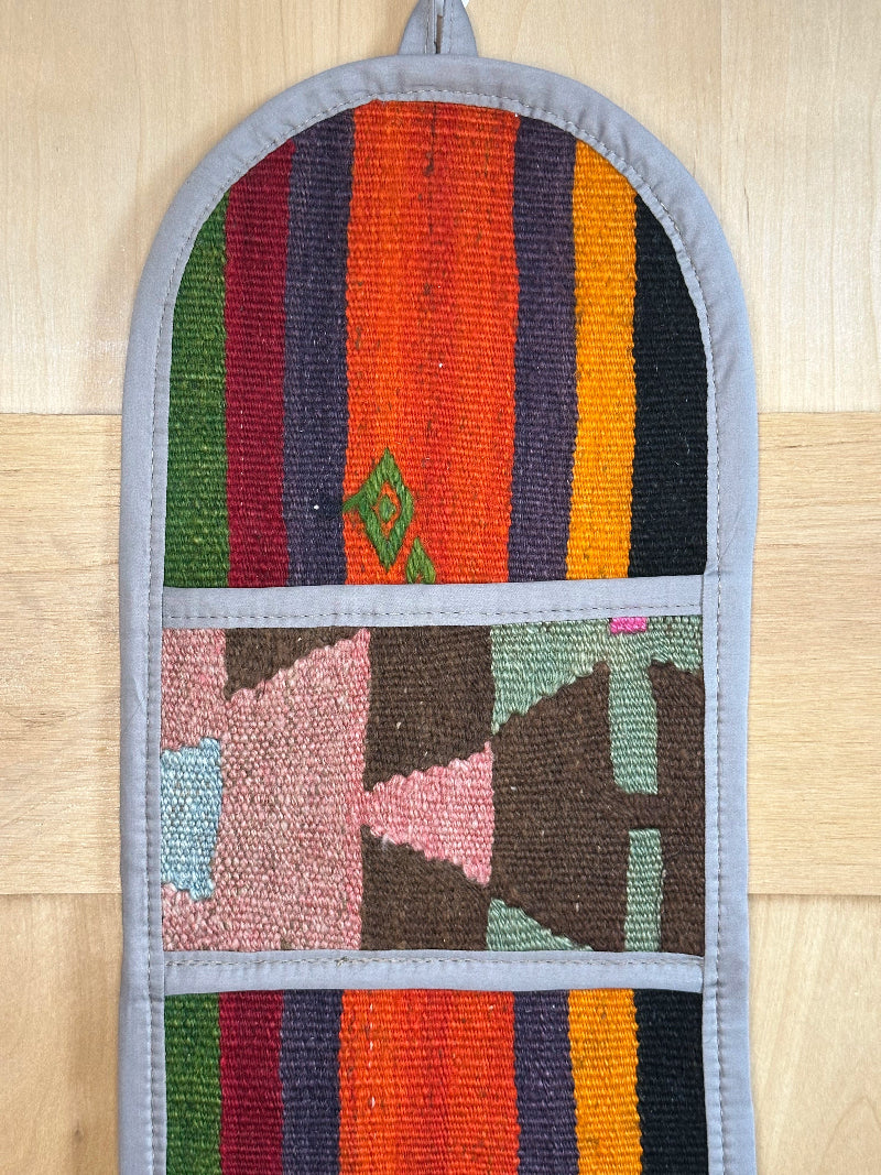 Decorative, handmade Turkish rug wall organizer with vibrant stripe designs and 3 storage pockets. Upcycled vintage textile art by High Pile Designs.