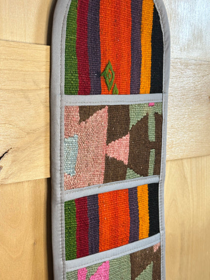 Decorative, handmade Turkish rug wall organizer with vibrant stripe designs and 3 storage pockets. Upcycled vintage textile art by High Pile Designs.