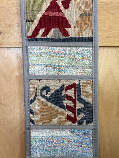 Decorative, handmade Turkish rug wall organizer with vibrant stripe designs and 3 storage pockets. Upcycled vintage textile art by High Pile Designs. Featuring wrapped gifts.