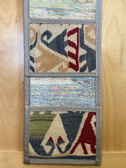 Decorative, handmade Turkish rug wall organizer with vibrant stripe designs and 3 storage pockets. Upcycled vintage textile art by High Pile Designs. Featuring wrapped gifts.
