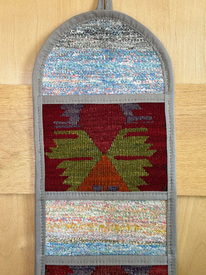 Decorative, handmade Turkish rug wall organizer with vibrant stripe designs and 3 storage pockets. Upcycled vintage textile art by High Pile Designs. Featuring wrapped gifts.